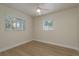 Bright bedroom with wood floors, a ceiling fan, and two windows offering natural light and scenic views at 2010 Bayview Pl, Indian Rocks Beach, FL 33785