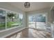 Bright dining area with wood floors, a modern light fixture, and views of the backyard through large windows at 2010 Bayview Pl, Indian Rocks Beach, FL 33785