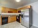 A well lit kitchen featuring stainless steel appliances, wood cabinets, and light marble-patterned flooring at 21032 Voyager Blvd # 8, Land O Lakes, FL 34638