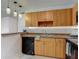 Kitchen with stainless steel sink, dishwasher, wood cabinets, and hanging pendant lights at 21032 Voyager Blvd # 8, Land O Lakes, FL 34638