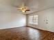 Bright living room featuring hardwood floors, ceiling fan, and window; front door on right at 21032 Voyager Blvd # 8, Land O Lakes, FL 34638