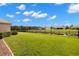 Lush backyard with green grass, a black fence, and a tranquil pond at 2350 126Th E Dr, Parrish, FL 34219