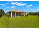 Home backyard with lush green grass and a screened-in patio at 2350 126Th E Dr, Parrish, FL 34219