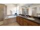 Bright bathroom featuring a soaking tub, walk-in shower, dual sinks, and a large mirror at 2350 126Th E Dr, Parrish, FL 34219