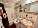 Cozy bathroom featuring a tub, tiled walls, and vibrant floral wallpaper at 2434 Australia E Way # 38, Clearwater, FL 33763