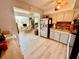 Kitchen flowing to a dining room with light wood flooring and featuring white appliances and wooden table at 2434 Australia E Way # 38, Clearwater, FL 33763