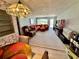 Living room featuring carpet, chandelier, red sofas, and natural light from the sliding glass door at 2434 Australia E Way # 38, Clearwater, FL 33763