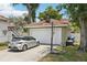 View of detached garage with 2 car garage door, basketball hoop, driveway with a car, and trash bins at 2616 11Th N St, St Petersburg, FL 33704