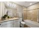 A well-lit bathroom showcasing a granite vanity top and tub with tiled walls at 3091 King Fern Dr, Wimauma, FL 33598