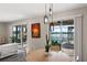 Bright dining area with stylish pendant lighting and sliding glass doors to a screened lanai and pool at 3091 King Fern Dr, Wimauma, FL 33598