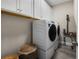 A cozy laundry room with ample white cabinets for storage and a sleek washer and dryer set at 3091 King Fern Dr, Wimauma, FL 33598