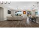 Open-concept living room with wood-look tile flooring, a comfortable sofa, and views of the lanai and lake at 3091 King Fern Dr, Wimauma, FL 33598