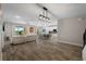 Open-concept living room with tile floors, white sofa, and views of the lanai, pool, and kitchen area at 3091 King Fern Dr, Wimauma, FL 33598