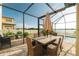 A screened patio with a dining table, chairs, and views of the pool and lake at 3091 King Fern Dr, Wimauma, FL 33598