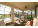 Outdoor seating on a covered patio with a ceiling fan and views of the pool and backyard at 3091 King Fern Dr, Wimauma, FL 33598