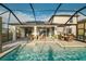 Stunning pool area with covered patio, outdoor seating, and pristine pool, creating an inviting backyard retreat at 3091 King Fern Dr, Wimauma, FL 33598