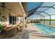 Inviting outdoor living space with a screened-in pool, patio seating, and a serene lake view, perfect for entertaining at 3091 King Fern Dr, Wimauma, FL 33598