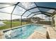 Clear blue screened-in pool featuring a sun shelf, hammock, and view of neighborhood, ideal for summertime fun at 3091 King Fern Dr, Wimauma, FL 33598