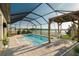 Relaxing screened-in pool area with a hammock, spa, and views of the lake, offering the perfect outdoor retreat at 3091 King Fern Dr, Wimauma, FL 33598