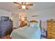 Comfortable bedroom featuring a ceiling fan, wood floors, and a bright window at 311 Knottwood Ct, Sun City Center, FL 33573