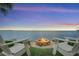 Enjoy picturesque waterfront views from the backyard fire pit, perfect for relaxing evenings and entertaining guests at 3236 Gulf Winds Cir, Hernando Beach, FL 34607