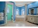 Bright and stylish bathroom with blue walls, architectural columns, soaking tub and vanity at 3236 Gulf Winds Cir, Hernando Beach, FL 34607