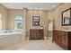 This bathroom features a soaking tub, two vanities, neutral paint, white tiling, and one window at 3236 Gulf Winds Cir, Hernando Beach, FL 34607