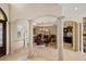 Elegant dining room with decorative columns, travertine flooring, and views into the kitchen at 3236 Gulf Winds Cir, Hernando Beach, FL 34607