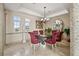 Bright dining room with a modern chandelier, travertine flooring, and plenty of natural light at 3236 Gulf Winds Cir, Hernando Beach, FL 34607
