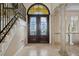 Elegant foyer with ornate double doors and a staircase featuring wrought iron railings at 3236 Gulf Winds Cir, Hernando Beach, FL 34607