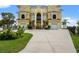 Eye-catching exterior showcasing a luxury yellow residence with a grand entrance and manicured lawn at 3236 Gulf Winds Cir, Hernando Beach, FL 34607