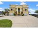 Grand exterior of a yellow luxury home featuring multiple balconies and a well-manicured front yard at 3236 Gulf Winds Cir, Hernando Beach, FL 34607