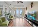 Comfortable living room with hardwood floors, green chairs, and sliding glass doors leading to the outdoor patio at 3236 Gulf Winds Cir, Hernando Beach, FL 34607