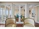 Double French doors give a glimpse of another room, hardwood floors, chairs, and natural light in this living space at 3236 Gulf Winds Cir, Hernando Beach, FL 34607