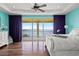 Bright bedroom with water views, hardwood floors, ceiling fan, and sliding door to a balcony at 3236 Gulf Winds Cir, Hernando Beach, FL 34607