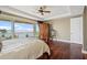 This main bedroom features hardwood floors, a ceiling fan, and floor-to-ceiling sliding glass doors to a balcony at 3236 Gulf Winds Cir, Hernando Beach, FL 34607