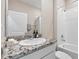 Charming bathroom featuring granite countertop, vanity and shower tub combo with tile surround at 33700 Hamilton Hill Ln, Wesley Chapel, FL 33545