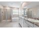 Well-lit bathroom boasts a shower, tub, and double vanity with granite countertops for a spa-like experience at 33700 Hamilton Hill Ln, Wesley Chapel, FL 33545