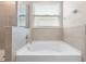 Close up on tub in the bright bathroom, featuring tile surround, and chrome faucet at 33700 Hamilton Hill Ln, Wesley Chapel, FL 33545
