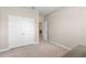 A light and airy bedroom featuring neutral carpeting, paint and trim plus an adjacent closet with double doors at 33700 Hamilton Hill Ln, Wesley Chapel, FL 33545
