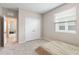 A neutral bedroom with carpet, a window and closet with folding doors at 33700 Hamilton Hill Ln, Wesley Chapel, FL 33545