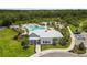Stunning aerial view of a community pool with palm trees and a large clubhouse at 33700 Hamilton Hill Ln, Wesley Chapel, FL 33545