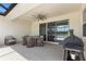 Covered patio with outdoor seating and grill, ceiling fan and view to lake at 33700 Hamilton Hill Ln, Wesley Chapel, FL 33545