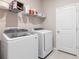 A well-equipped laundry room featuring modern appliances, wire shelving, and ample storage space at 33700 Hamilton Hill Ln, Wesley Chapel, FL 33545