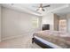 Main bedroom with tray ceiling, fan, and two windows at 33700 Hamilton Hill Ln, Wesley Chapel, FL 33545