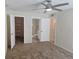 Comfortable bedroom with a ceiling fan, multiple entryways, and access to the bathroom and closet at 3455 Countryside Blvd # 33, Clearwater, FL 33761