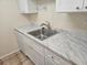Kitchen sink with marble countertops, stainless steel faucet and dishwasher at 3455 Countryside Blvd # 33, Clearwater, FL 33761