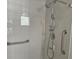 Walk-in shower features a handheld shower head, grab bars, and a built-in niche at 3455 Countryside Blvd # 33, Clearwater, FL 33761