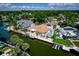 An aerial view of this waterfront home with pool showcases lush landscaping, private dock, and water access at 3691 Center Cir, Largo, FL 33774