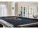 Bright game room featuring a pool table with black felt, stylish decor, and natural light from the french doors at 3691 Center Cir, Largo, FL 33774
